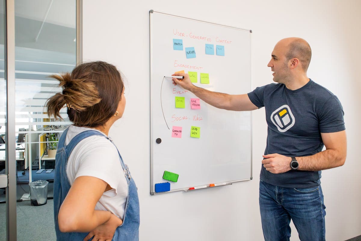 Dos colegas planificando estrategia de automatización ligera en pizarra